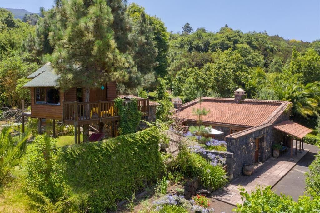 Vista aérea de Hacienda Verde · casas rurales de piedra y la cabaña de madera entre la arboleda de la finca